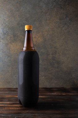 Koyu kahverengi plastik bira şişesi ya da ahşap arka planda fotokopi alanı olan kvass.