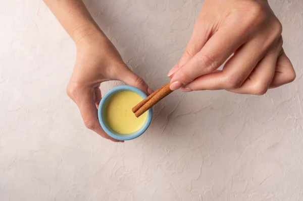 Las manos de las mujeres en forma de corazón sostienen la taza de cerámica azul con el té tradicional de masala chai indio. Vista superior, espacio de copia — Foto de Stock