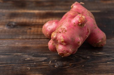 Son moda çirkin organik patatesler ahşap bir arka planda ev bahçesinden çıkmış bir hayvana benzer.