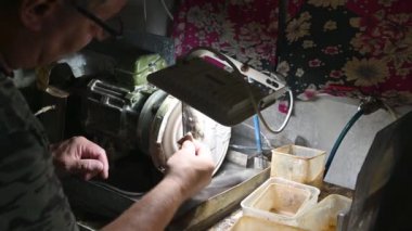Mücevher yapmak için makinede kehribar öğütme ustası