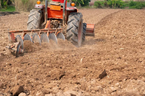 Tracteur cultivant le champ au printemps, le travail du sol est l'agriculture — Photo