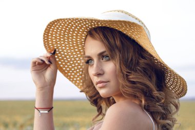 Ayçiçeği tarlasında bir şapka giyen genç güzel kadın