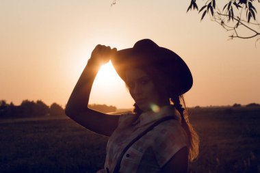 şapkasını seyir dokunmadan bir kadın silueti.