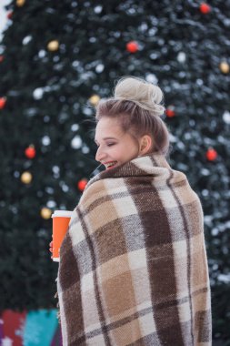 kış tatili, sıcak içecekler, yünlü ekose ve insanlar - genç kadınla mutlu Noel ışıkları açık havada kahve