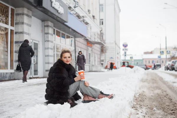 Dziewczyna Siedzi Śniegu Mieście Krawężnik Pokryte Śniegiem Styl Życia Zimowy — Zdjęcie stockowe