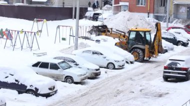 Şehirde kar yağışlı bir günde traktör temizliği. Kış Servis Aracı iş başında. Kar Kaldırma Aracı