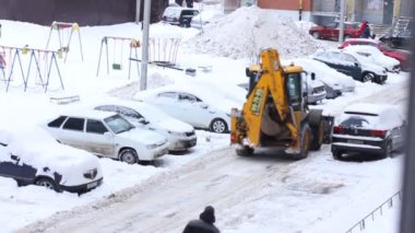 Şehirde kar yağışlı bir günde traktör temizliği. Kış Servis Aracı iş başında. Kar Kaldırma Aracı