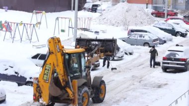 Şehirde kar yağışlı bir günde traktör temizliği. Kış Servis Aracı iş başında. Kar Kaldırma Aracı