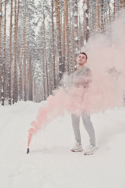 Temperature, freezing, cold snap. Bearded man smoking cigarette with skates in snowy forest. Man in thermal jacket, beard warm in winter. Winter sport, Christmas. skincare and beard care in winter.