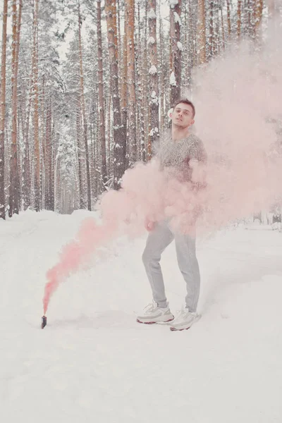 Temperature, freezing, cold snap. Bearded man smoking cigarette with skates in snowy forest. Man in thermal jacket, beard warm in winter. Winter sport, Christmas. skincare and beard care in winter.