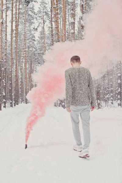 Temperature, freezing, cold snap. Bearded man smoking cigarette with skates in snowy forest. Man in thermal jacket, beard warm in winter. Winter sport, Christmas. skincare and beard care in winter.