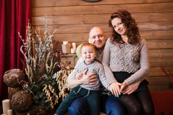 Noel 'de mutlu aile portre, Anne, baba ve oğul evde, chritmas dekorasyon ve onların etrafında sunar Mama sandalyesinde oturan