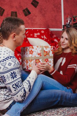 Mutlu genç insanlar Noel ağacının yakınında şömine tarafından birbirlerine hediyeler vermek. Lovers çift yeni yıl için beklentilerin dolu