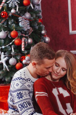 Mutlu genç insanlar Noel ağacının yakınında şömine tarafından birbirlerine hediyeler vermek. Lovers çift yeni yıl için beklentilerin dolu
