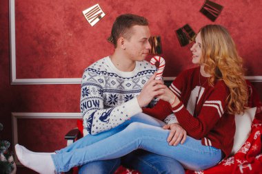 Mutlu genç insanlar Noel ağacının yakınında şömine tarafından birbirlerine hediyeler vermek. Lovers çift yeni yıl için beklentilerin dolu