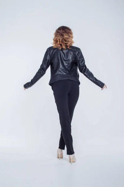 Mujer sensual de moda bastante joven posando sobre fondo blanco con un traje de chaqueta de cuero estilo hipster. Elegante chica de moda hipster en ropa negra y camisa blanca . — Foto de Stock