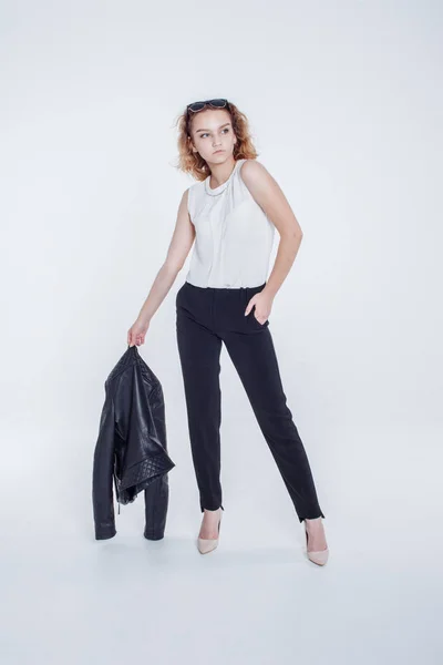 Mujer sensual de moda bastante joven posando sobre fondo blanco con un traje de chaqueta de cuero estilo hipster. Elegante chica de moda hipster en ropa negra y camisa blanca . — Foto de Stock