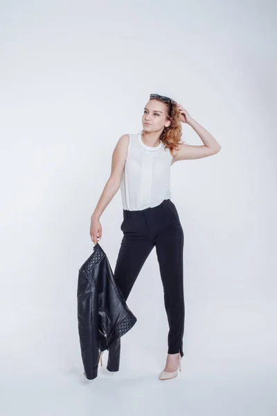 Mujer sensual de moda bastante joven posando sobre fondo blanco con un traje de chaqueta de cuero estilo hipster. Elegante chica de moda hipster en ropa negra y camisa blanca . —  Fotos de Stock