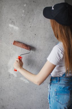 Genç Kafkas kadın el bir odada bir reparing yeni duvar önünde rulo boyama seçici odak.