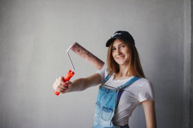 Genç Kafkas kadın el bir odada bir reparing yeni duvar önünde rulo boyama seçici odak.