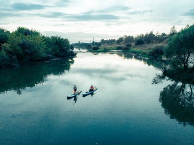 Göldeki SUP tahtalı turistlerin en iyi görüntüsü. Sörf yapan insanlarla dolu güzel, berrak bir su. Arka planda kürek çeken insanların olduğu deniz manzarası