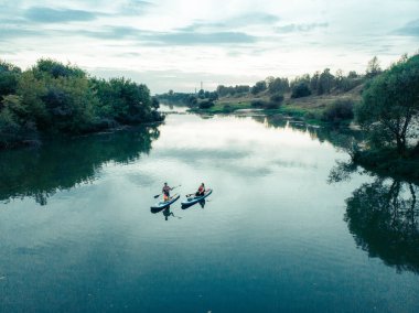 Göldeki SUP tahtalı turistlerin en iyi görüntüsü. Sörf yapan insanlarla dolu güzel, berrak bir su. Arka planda kürek çeken insanların olduğu deniz manzarası