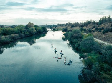 Göldeki SUP tahtalı turistlerin en iyi görüntüsü. Sörf yapan insanlarla dolu güzel, berrak bir su. Arka planda kürek çeken insanların olduğu deniz manzarası