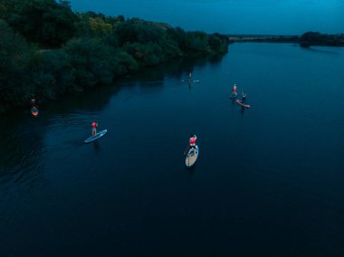 Göldeki SUP tahtalı turistlerin en iyi görüntüsü. Sörf yapan insanlarla dolu güzel, berrak bir su. Arka planda kürek çeken insanların olduğu deniz manzarası