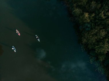 Göldeki SUP tahtalı turistlerin en iyi görüntüsü. Sörf yapan insanlarla dolu güzel, berrak bir su. Arka planda kürek çeken insanların olduğu deniz manzarası
