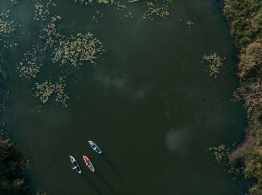 Göldeki SUP tahtalı turistlerin en iyi görüntüsü. Sörf yapan insanlarla dolu güzel, berrak bir su. Arka planda kürek çeken insanların olduğu deniz manzarası