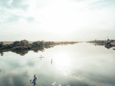 Göldeki SUP tahtalı turistlerin en iyi görüntüsü. Sörf yapan insanlarla dolu güzel, berrak bir su. Arka planda kürek çeken insanların olduğu deniz manzarası