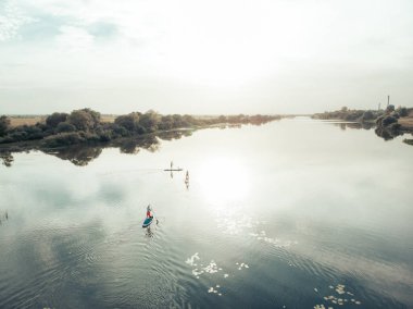 Göldeki SUP tahtalı turistlerin en iyi görüntüsü. Sörf yapan insanlarla dolu güzel, berrak bir su. Arka planda kürek çeken insanların olduğu deniz manzarası