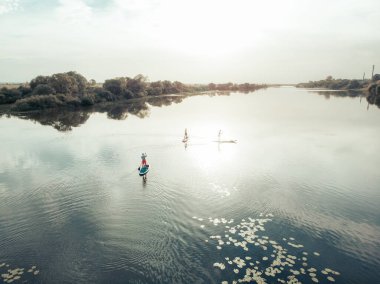 Göldeki SUP tahtalı turistlerin en iyi görüntüsü. Sörf yapan insanlarla dolu güzel, berrak bir su. Arka planda kürek çeken insanların olduğu deniz manzarası