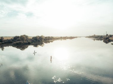Göldeki SUP tahtalı turistlerin en iyi görüntüsü. Sörf yapan insanlarla dolu güzel, berrak bir su. Arka planda kürek çeken insanların olduğu deniz manzarası