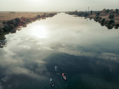 Göldeki SUP tahtalı turistlerin en iyi görüntüsü. Sörf yapan insanlarla dolu güzel, berrak bir su. Arka planda kürek çeken insanların olduğu deniz manzarası