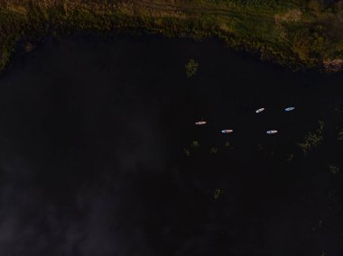 Göldeki SUP tahtalı turistlerin en iyi görüntüsü. Sörf yapan insanlarla dolu güzel, berrak bir su. Arka planda kürek çeken insanların olduğu deniz manzarası