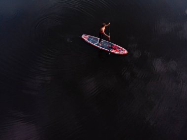 Göldeki SUP tahtalı turistlerin en iyi görüntüsü. Sörf yapan insanlarla dolu güzel, berrak bir su. Arka planda kürek çeken insanların olduğu deniz manzarası