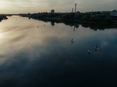 Göldeki SUP tahtalı turistlerin en iyi görüntüsü. Sörf yapan insanlarla dolu güzel, berrak bir su. Arka planda kürek çeken insanların olduğu deniz manzarası