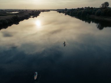Göldeki SUP tahtalı turistlerin en iyi görüntüsü. Sörf yapan insanlarla dolu güzel, berrak bir su. Arka planda kürek çeken insanların olduğu deniz manzarası