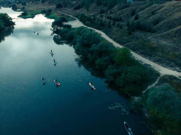 Göldeki SUP tahtalı turistlerin en iyi görüntüsü. Sörf yapan insanlarla dolu güzel, berrak bir su. Arka planda kürek çeken insanların olduğu deniz manzarası