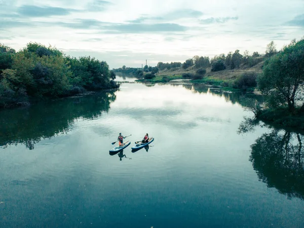 Göldeki SUP tahtalı turistlerin en iyi görüntüsü. Sörf yapan insanlarla dolu güzel, berrak bir su. Arka planda kürek çeken insanların olduğu deniz manzarası