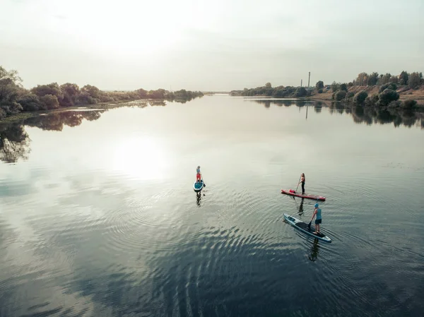 Göldeki SUP tahtalı turistlerin en iyi görüntüsü. Sörf yapan insanlarla dolu güzel, berrak bir su. Arka planda kürek çeken insanların olduğu deniz manzarası