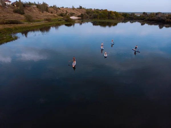 Supボード付きの湖での観光客のトップビュー サーフィンに従事ボード上に浮かぶ人々と美しい澄んだ水 背景の地平線にボードに乗っている人々との海 — ストック写真