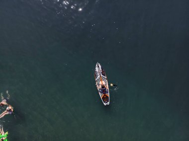 Stand Up Paddle tahtasında çekici bir kadın yemek masasında kürek çeken ve şeffaf suyun tadını çıkaran bir kadın. Tropik seyahat, seyahat tutkusu ve su aktivitesi konsepti. Gün batımı ve rahatlama