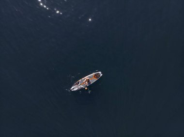 Stand Up Paddle tahtasında çekici bir kadın yemek masasında kürek çeken ve şeffaf suyun tadını çıkaran bir kadın. Tropik seyahat, seyahat tutkusu ve su aktivitesi konsepti. Gün batımı ve rahatlama