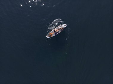Stand Up Paddle tahtasında çekici bir kadın yemek masasında kürek çeken ve şeffaf suyun tadını çıkaran bir kadın. Tropik seyahat, seyahat tutkusu ve su aktivitesi konsepti. Gün batımı ve rahatlama