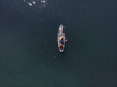 Stand Up Paddle tahtasında çekici bir kadın yemek masasında kürek çeken ve şeffaf suyun tadını çıkaran bir kadın. Tropik seyahat, seyahat tutkusu ve su aktivitesi konsepti. Gün batımı ve rahatlama