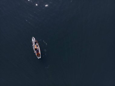 Stand Up Paddle tahtasında çekici bir kadın yemek masasında kürek çeken ve şeffaf suyun tadını çıkaran bir kadın. Tropik seyahat, seyahat tutkusu ve su aktivitesi konsepti. Gün batımı ve rahatlama