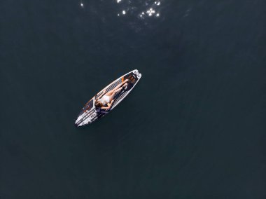 Stand Up Paddle tahtasında çekici bir kadın yemek masasında kürek çeken ve şeffaf suyun tadını çıkaran bir kadın. Tropik seyahat, seyahat tutkusu ve su aktivitesi konsepti. Gün batımı ve rahatlama