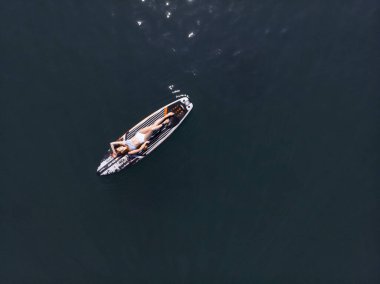 Stand Up Paddle tahtasında çekici bir kadın yemek masasında kürek çeken ve şeffaf suyun tadını çıkaran bir kadın. Tropik seyahat, seyahat tutkusu ve su aktivitesi konsepti. Gün batımı ve rahatlama